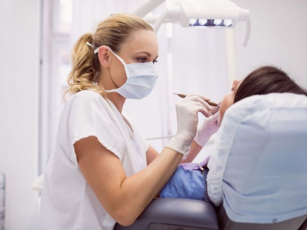 Zahnärztin führt ein Parodontologie-Behandlung bei einem Patienten in München Schwabing durch