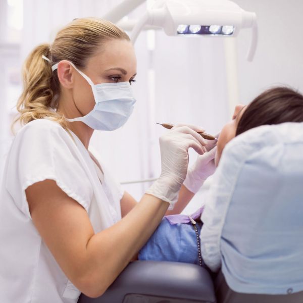 Zahnärztin führt ein Parodontologie-Behandlung bei einem Patienten in München Schwabing durch
